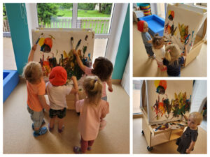Dzieci malują pędzlami na sztaludze.
